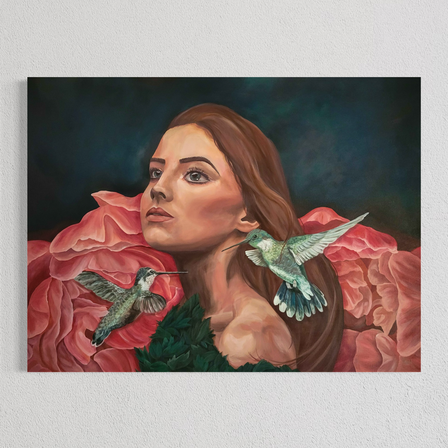 A rectangular wall art painting hanging on a light textured wall, depicting a woman with long brown hair surrounded by large pink flowers and two hummingbirds against a dark blue-green background.