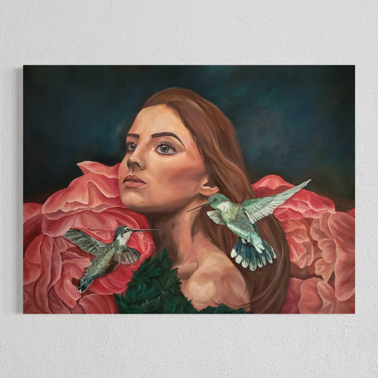 A rectangular wall art painting hanging on a light textured wall, depicting a woman with long brown hair surrounded by large pink flowers and two hummingbirds against a dark blue-green background.